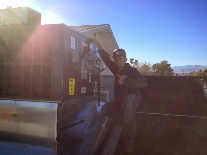 HVAC technician performing HVAC Inspection on a rooftop unit in Solana Beach